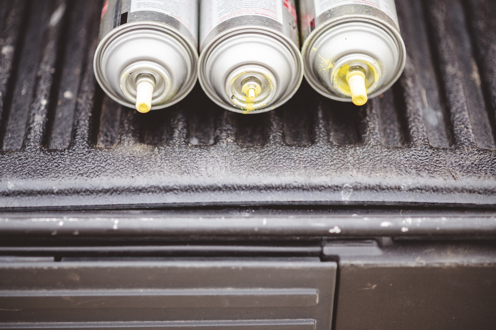 Spray paints on a black metal surface